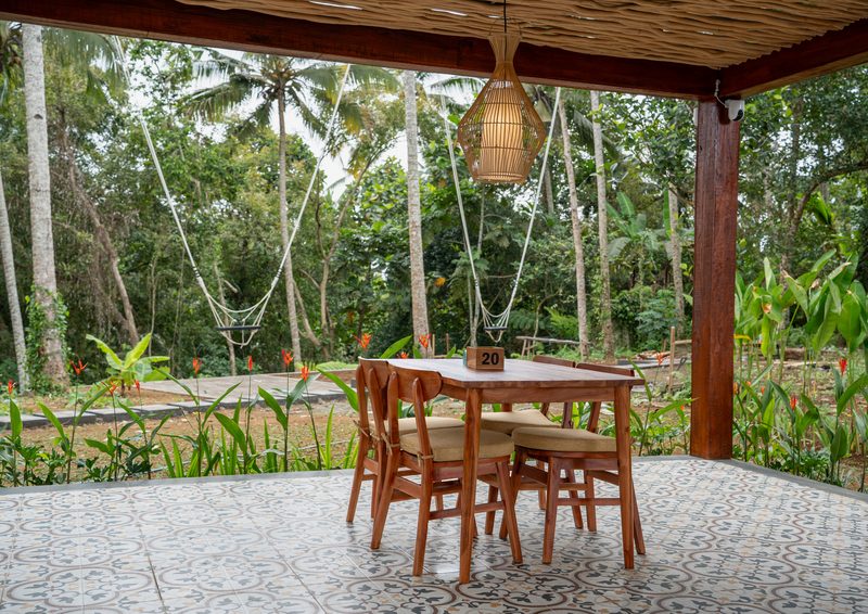 A table for four at the edge of the terrace, looking out over palms and hammocks